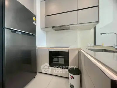 Modern kitchen with sleek cabinetry and built-in oven in a stylish apartment.