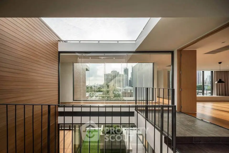 Modern multi-level home with open layout and large windows offering city views, featuring sleek wood and metal finishes.