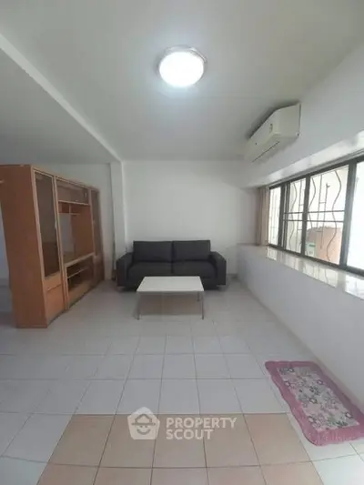 Spacious living room with modern sofa and large window for natural light