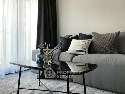 Modern living room with sleek gray sofa and glass coffee table