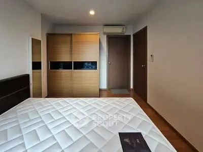 Modern bedroom with wooden wardrobe and comfortable mattress, perfect for relaxation.
