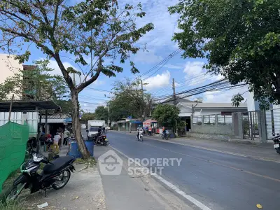Charming suburban street view with lush greenery and residential buildings, perfect for peaceful living.