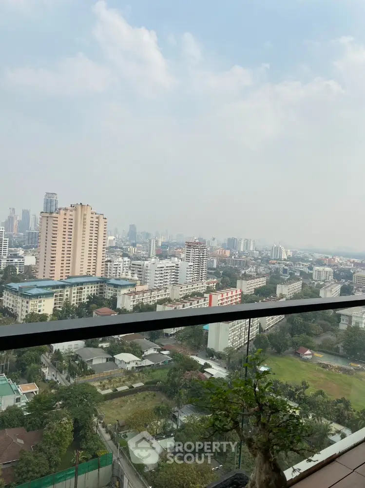 Stunning cityscape view from high-rise balcony with lush greenery and skyline