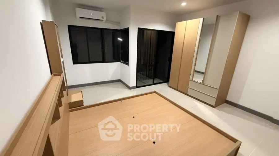 Spacious bedroom with modern wooden furniture and air conditioning