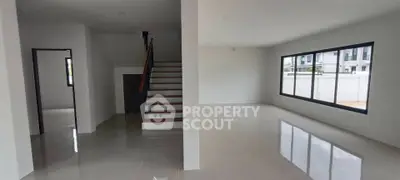 Spacious modern living room with large windows and staircase