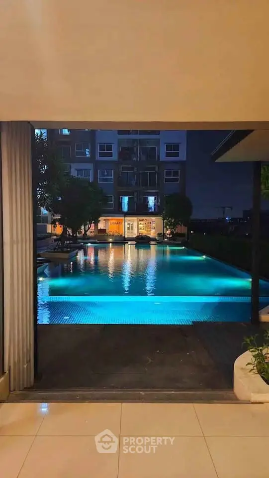 Luxurious night view of a modern apartment complex with illuminated swimming pool