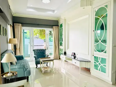 Elegant living room with stylish furniture and large windows offering natural light and garden view.