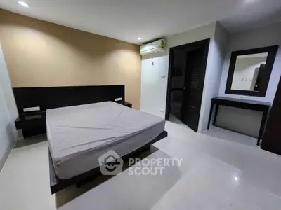 Spacious modern bedroom with minimalist design and neutral tones.