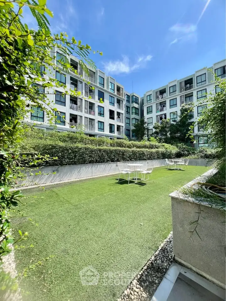 Modern apartment building with lush garden and outdoor seating area