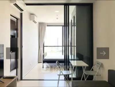Modern apartment with sliding glass doors leading to a bright bedroom and compact dining area.