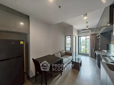 Modern living room with city view, sleek furniture, and open kitchen layout in urban apartment.