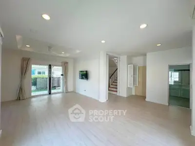 Spacious modern living room with large windows and light wood flooring