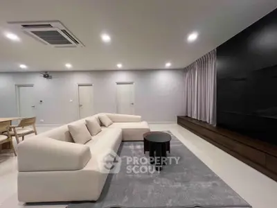 Spacious modern living room with sleek furniture and large TV setup