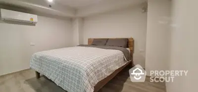 Spacious bedroom with modern decor and air conditioning unit