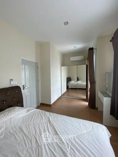 Spacious bedroom with mirrored wardrobe and elegant decor