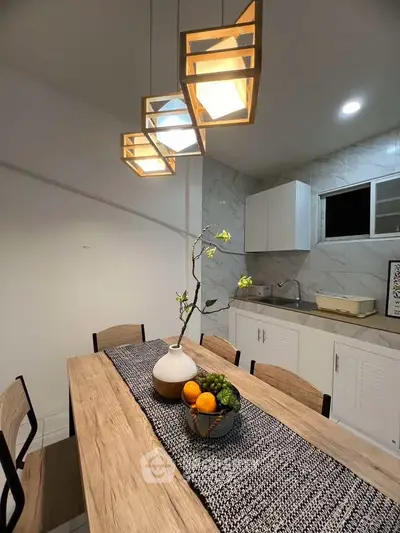 Modern kitchen with stylish lighting and wooden dining table