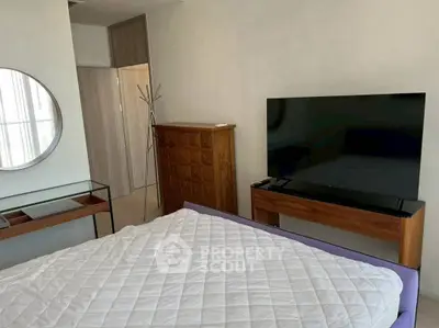 Modern bedroom with stylish furniture and large TV, perfect for relaxation.