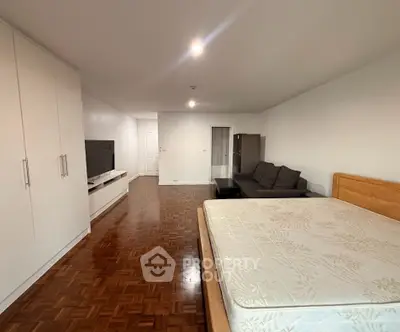 Spacious bedroom with wooden flooring and modern furniture