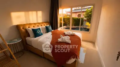 Cozy bedroom with elegant decor and pool view, perfect for relaxation and comfort.
