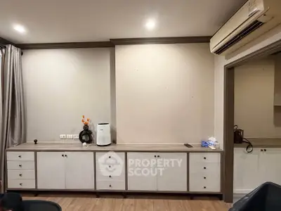 Spacious living room with modern cabinetry and air conditioning, perfect for comfortable living.