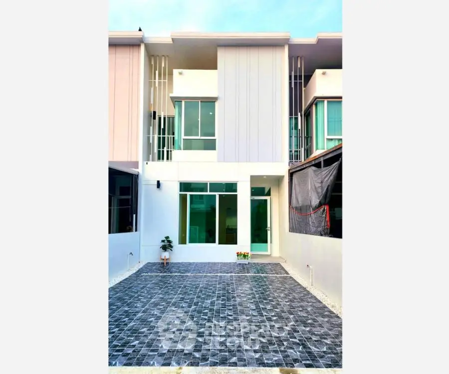 Modern townhouse exterior with spacious tiled courtyard and large windows
