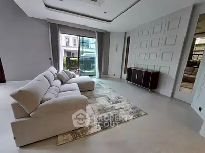 Spacious modern living room with elegant sofa and large window view.