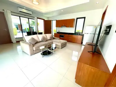 Spacious modern living room with sleek furniture and open kitchen layout