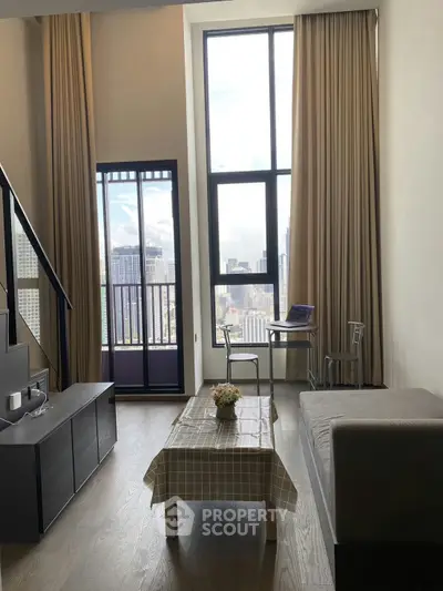 Modern living room with high ceilings and city view, featuring a cozy sofa and stylish decor.