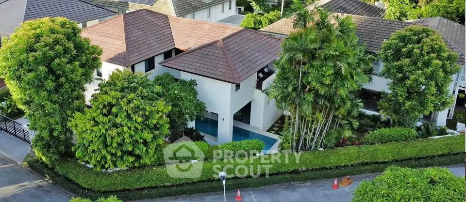 Luxurious villa with lush greenery and private pool in a serene neighborhood.