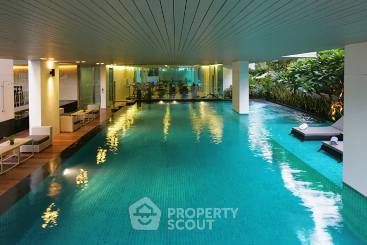 Luxurious indoor pool with modern design and lush greenery