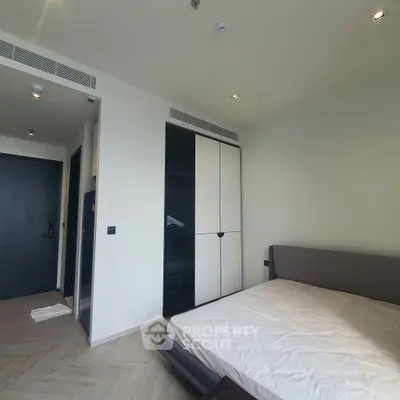 Modern bedroom with sleek design and ample storage in a contemporary apartment.