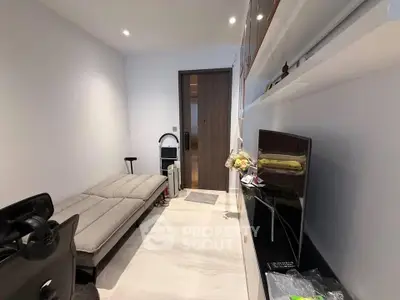 Modern living room with sleek furniture and minimalist design, featuring a comfortable sofa and wall-mounted TV.