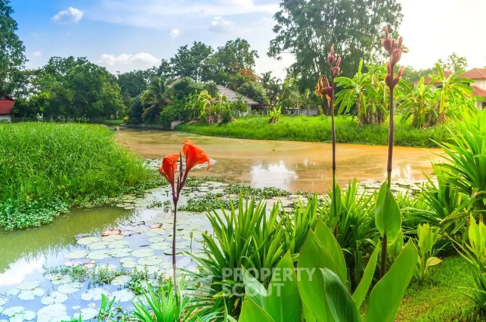 Scenic view of lush garden with pond and vibrant flowers, perfect for tranquil living.