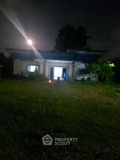 Charming single-story home with spacious yard under moonlit sky, perfect for serene living.
