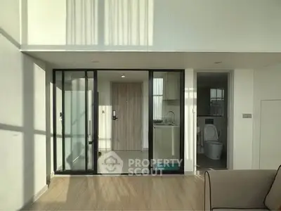 Modern apartment interior with glass sliding doors and natural light