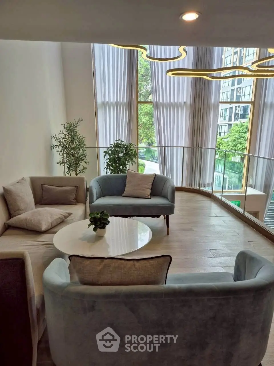 Elegant living room with modern furniture and large windows offering a scenic view.