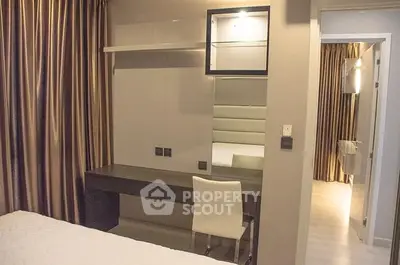 Modern bedroom with sleek furniture and elegant curtains, featuring a stylish vanity area.