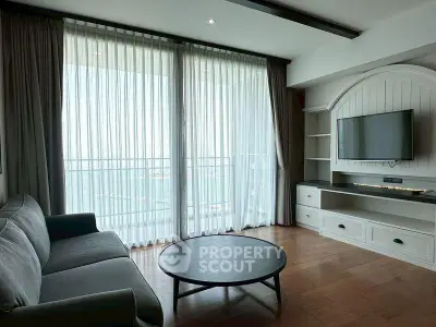 Spacious living room with large windows and modern furnishings, offering a bright and airy atmosphere.