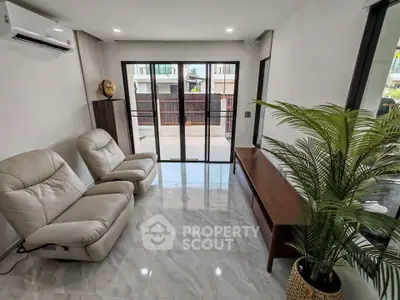 Modern living room with sleek furniture and large windows offering natural light.