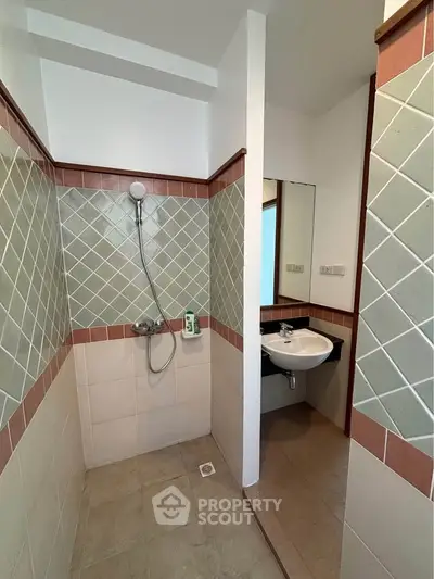 Charming bathroom with tiled shower and modern sink in cozy real estate property.