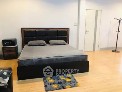 Spacious modern bedroom with stylish bed and wooden flooring