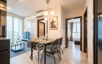 Modern apartment interior with dining area, living room, and bedroom, featuring stylish decor and natural light.
