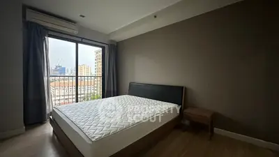 Spacious bedroom with city view and modern furnishings in urban apartment