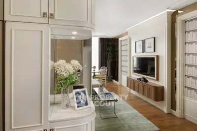Luxurious living room with elegant decor, built-in shelving, and modern entertainment center.