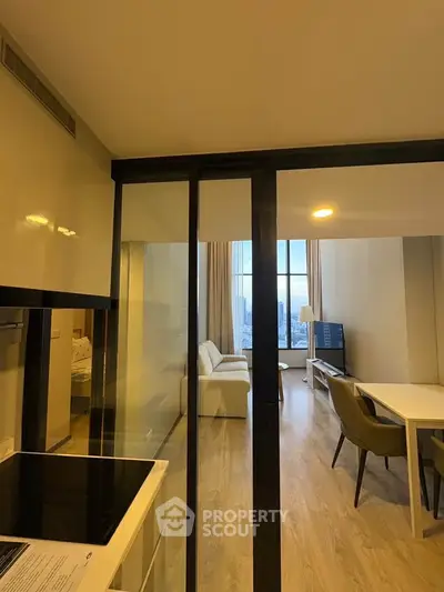 Modern open-layout apartment with city view, featuring sleek kitchen and spacious living area.