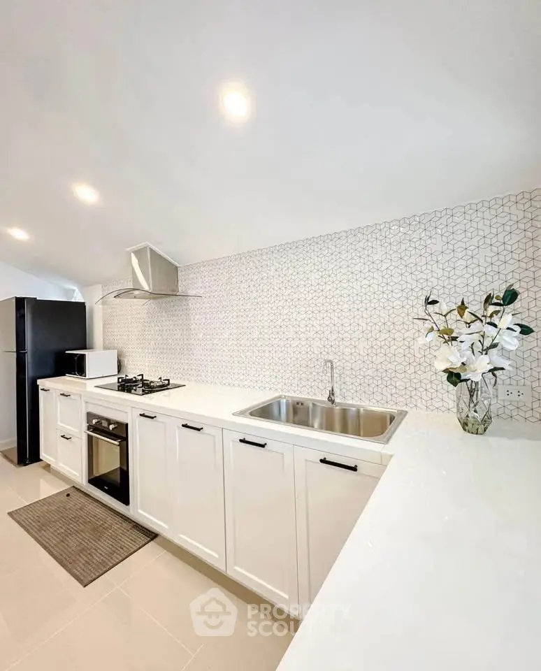 Modern kitchen with sleek white cabinets and gas stove in stylish apartment