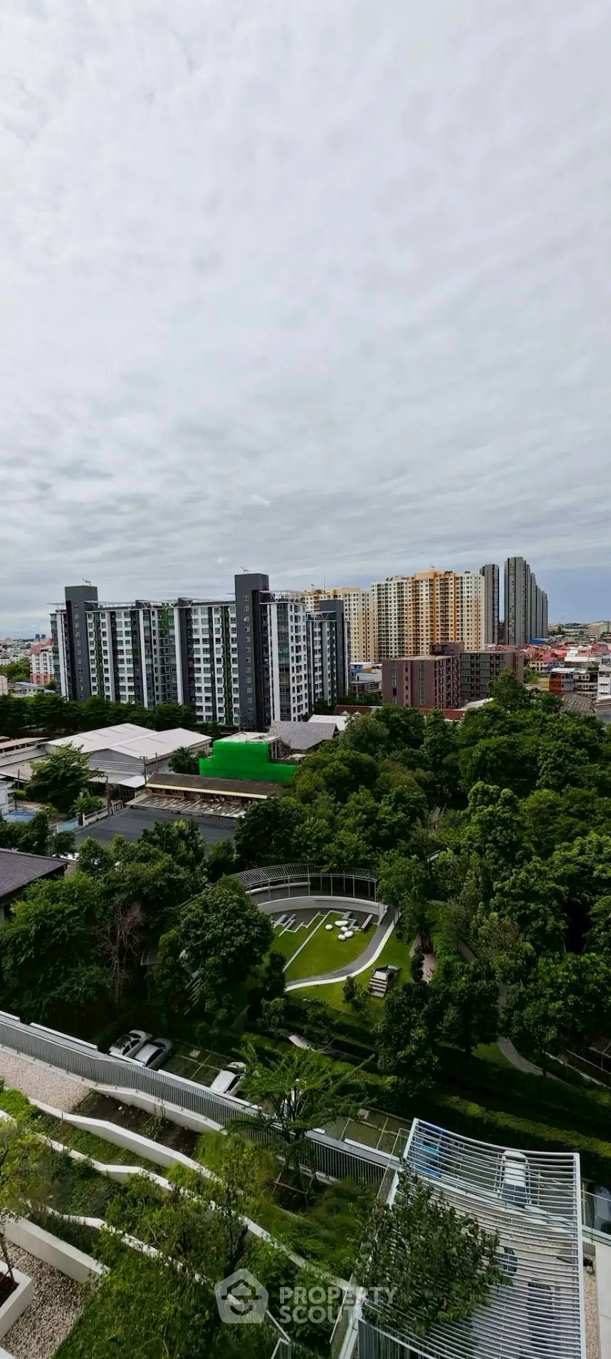 Stunning cityscape view with lush greenery and modern high-rise buildings.