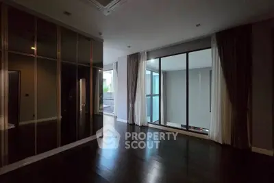 Spacious modern living room with floor-to-ceiling windows and dark wood flooring