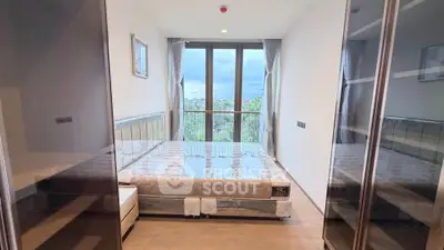 Modern bedroom with large windows and scenic view, featuring a comfortable bed and sleek design.