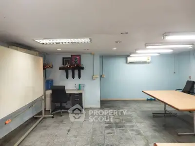 Spacious office room with modern furniture and ample lighting, ideal for productive work environment.